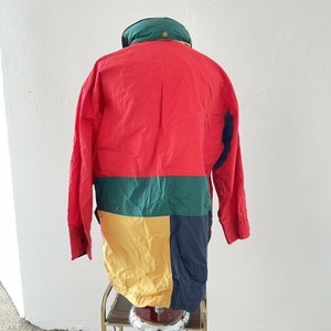 Puede incluir: Una chaqueta de color bloque con capucha, en rojo, verde, amarillo y azul.