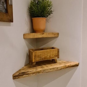 Pair of reclaimed scaffold board corner shelves, rustic industrial floating triangles for plants in a farmhouse-style corner.