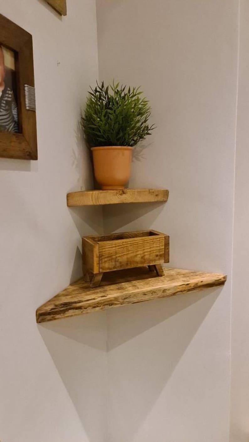 Pair of reclaimed scaffold board corner shelves, rustic industrial floating triangles for plants in a farmhouse-style corner.