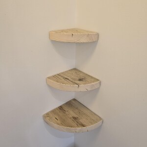 Reclaimed wood corner shelf set: three rustic round-corner scaffold-board shelves in a corner, ideal for plants.