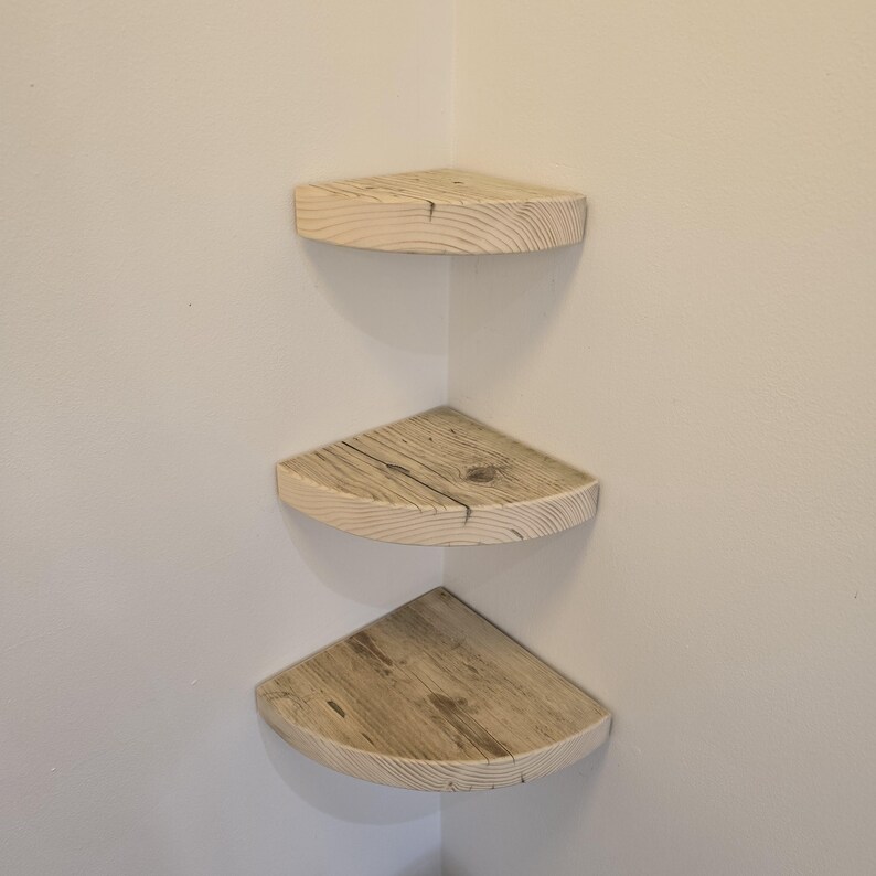 Reclaimed wood corner shelf set: three rustic round-corner scaffold-board shelves in a corner, ideal for plants.