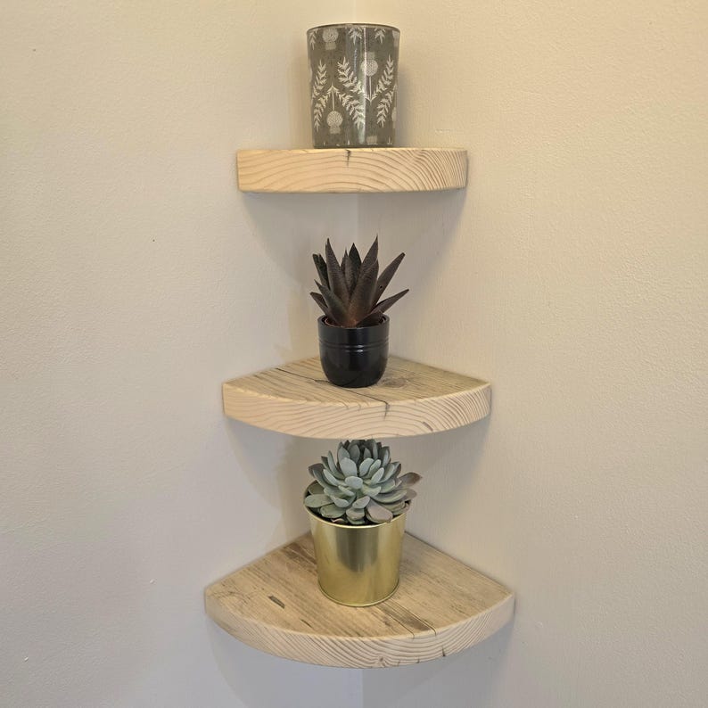 Reclaimed wood corner shelf set: three rustic round-corner scaffold-board shelves in a corner, ideal for plants.