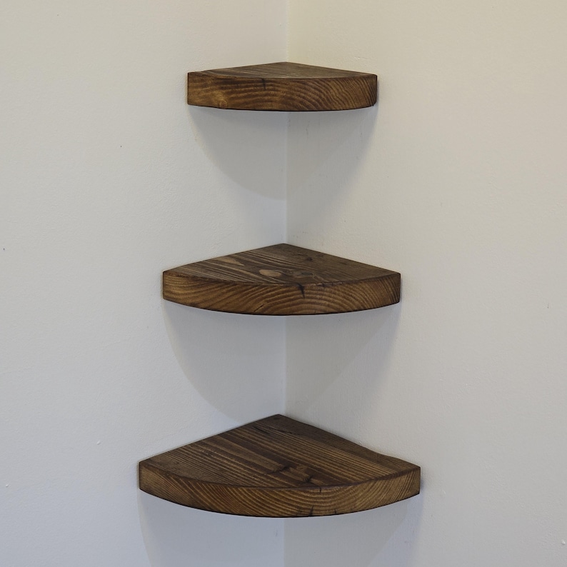 Reclaimed wood corner shelf set: three rustic round-corner scaffold-board shelves in a corner, ideal for plants.