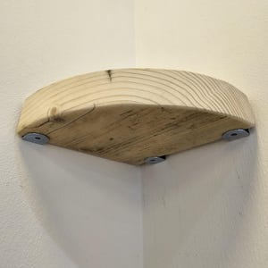 Reclaimed wood corner shelf set: three rustic round-corner scaffold-board shelves in a corner, ideal for plants.