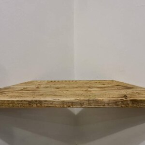 Pair of reclaimed scaffold board corner shelves, rustic industrial floating triangles for plants in a farmhouse-style corner.