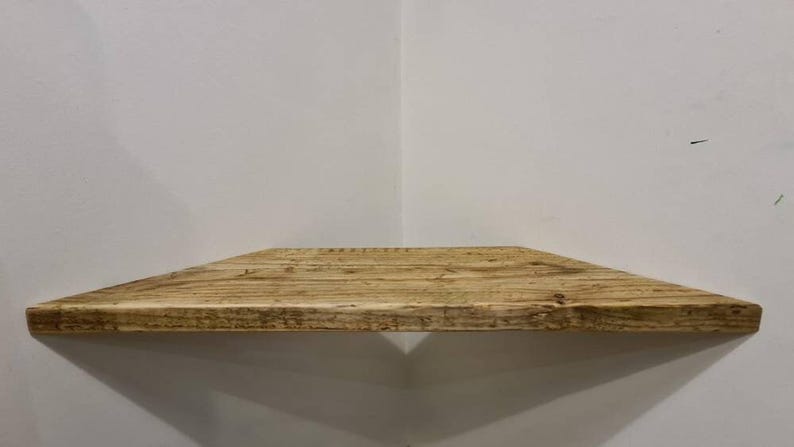 Pair of reclaimed scaffold board corner shelves, rustic industrial floating triangles for plants in a farmhouse-style corner.