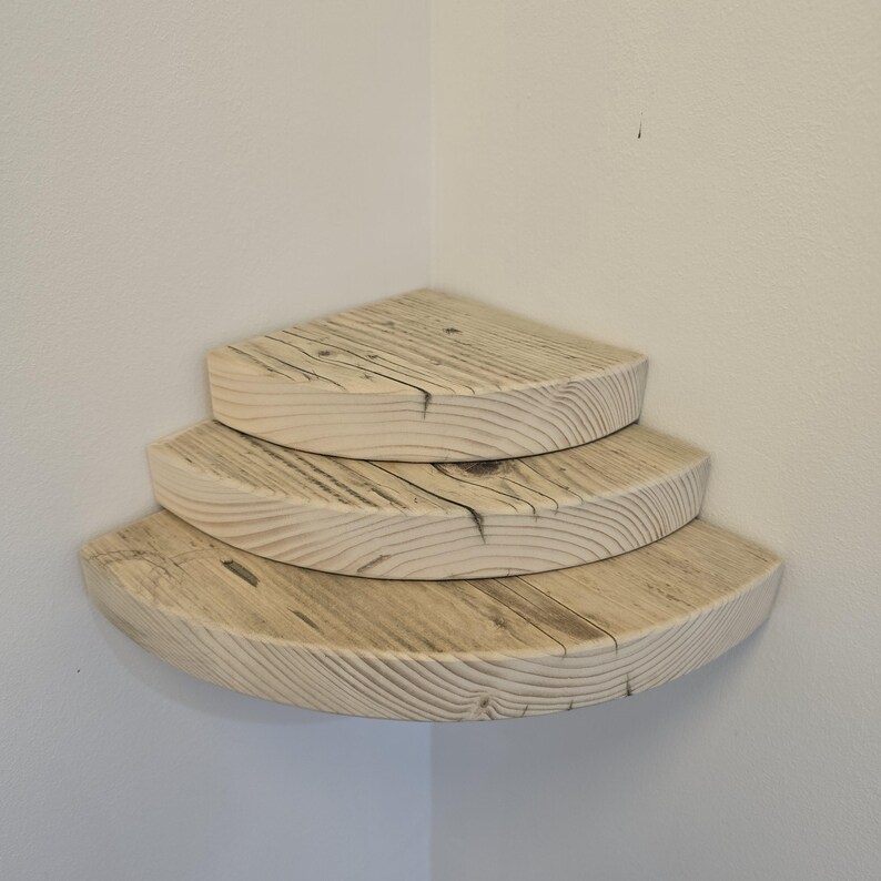 Reclaimed wood corner shelf set: three rustic round-corner scaffold-board shelves in a corner, ideal for plants.