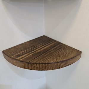Reclaimed wood corner shelf set: three rustic round-corner scaffold-board shelves in a corner, ideal for plants.