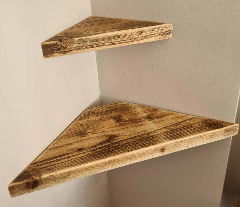 Pair of reclaimed scaffold board corner shelves, rustic industrial floating triangles for plants in a farmhouse-style corner.