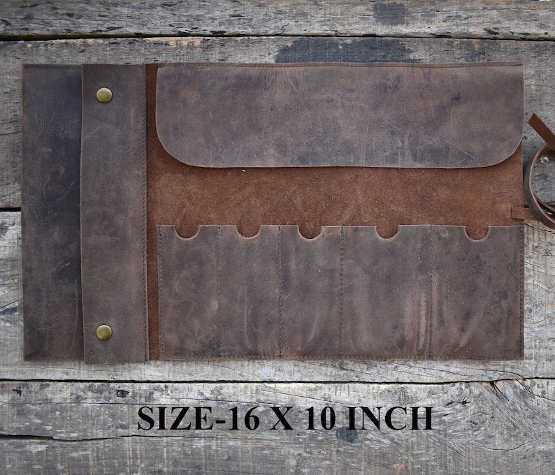 May include: Brown leather roll-up tool holder with six slots and a flap closure. The roll measures 16 x 10 inches.