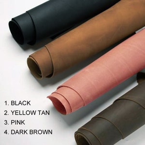 May include: Four rolls of leather in different colors: black, tan, pink, and dark brown. The leather is rolled up and the ends are visible.
