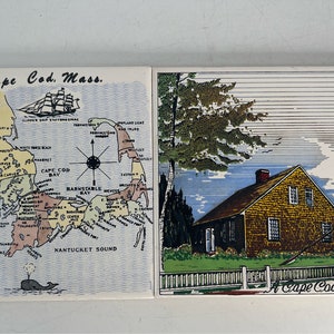 May include: Two vintage ceramic tiles depicting Cape Cod, Massachusetts. The first tile shows a map of Cape Cod with the text "Cape Cod, Mass." and a whale illustration. The second tile shows a yellow cottage with a white picket fence and the text "A Cape Cod Cottage".