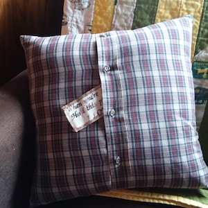 May include: A plaid pillow with a brown fabric patch that says "When you're hold this pillow, I love you".