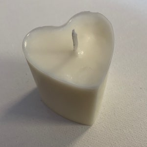 May include: A white heart-shaped candle with a single wick.