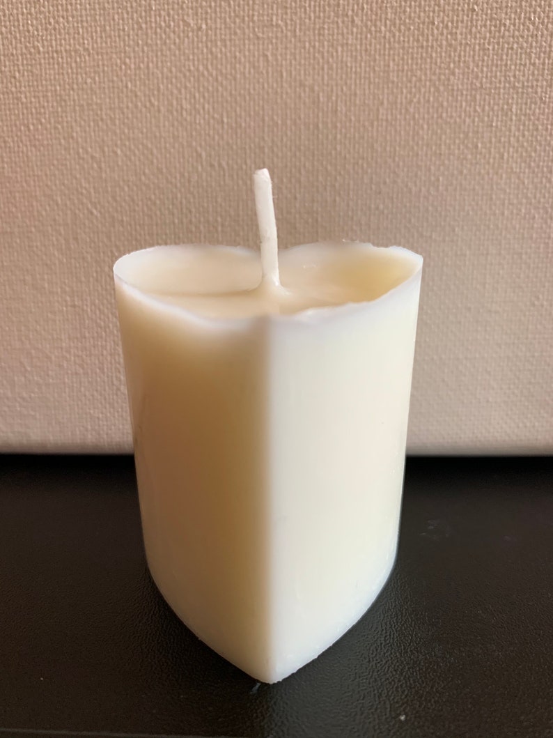 May include: A white heart-shaped candle with a single wick.