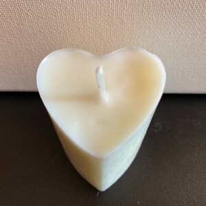 May include: A white heart-shaped candle with a single wick.