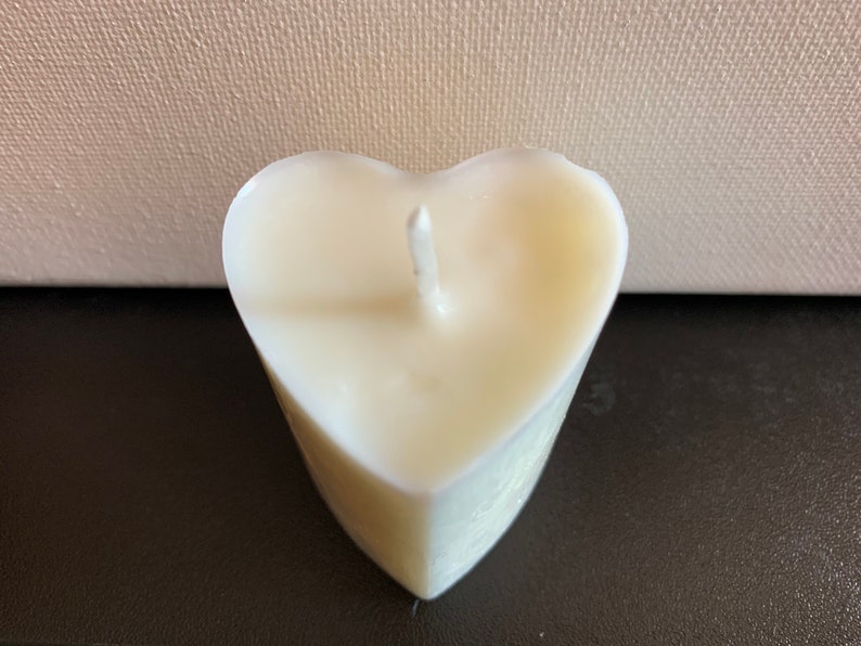 May include: A white heart-shaped candle with a single wick.