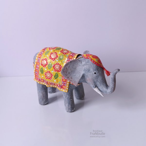 Eléphant sculpture en papier mâché. Figurine petit éléphant décoré avec ornements de fête dans le style indien. Éléphant et tapis coloré.