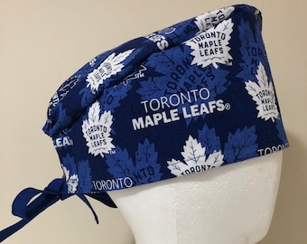 May include: Blue and white patterned surgical scrub hat with the text "Toronto Maple Leafs" repeated throughout. The hat has a tie at the back.