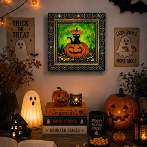 Op de afbeelding: Een ingelijst schilderij van een zwarte kat die in een uitgesneden pompoen zit tegen een groene achtergrond. Het schilderij hangt aan een muur, omringd door Halloween-decoraties zoals spookfiguren, pompoenen en boeken met verschillende titels.
