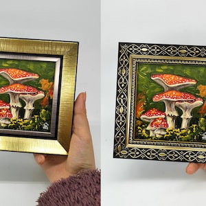 May include: A framed painting of red and white mushrooms with white spots on a green background. The frame is gold with a silver inner border.