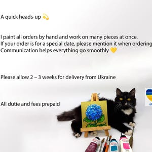 Pode incluir: Um gato preto e branco deitado ao lado de um pequeno cavalete de madeira com uma pintura quadrada de uma hort&ecirc;nsia azul sobre fundo dourado. Abaixo do cavalete est&atilde;o tr&ecirc;s tubos de tinta a &oacute;leo e dois pinc&eacute;is. Um &iacute;cone de cora&ccedil;&atilde;o azul e amarelo.