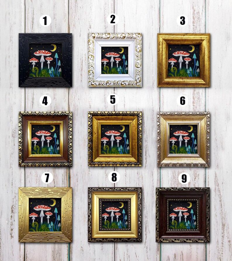 May include: Nine different framed prints of a mushroom illustration with a crescent moon and stars. The mushrooms are red with white spots and have blue stems. The frames are in various colours and styles, including black, white, gold, and brown.