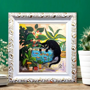 May include: A framed painting of a black cat peering into a fishbowl filled with colorful fish. The cat is surrounded by lush green plants in a white frame with gold accents.