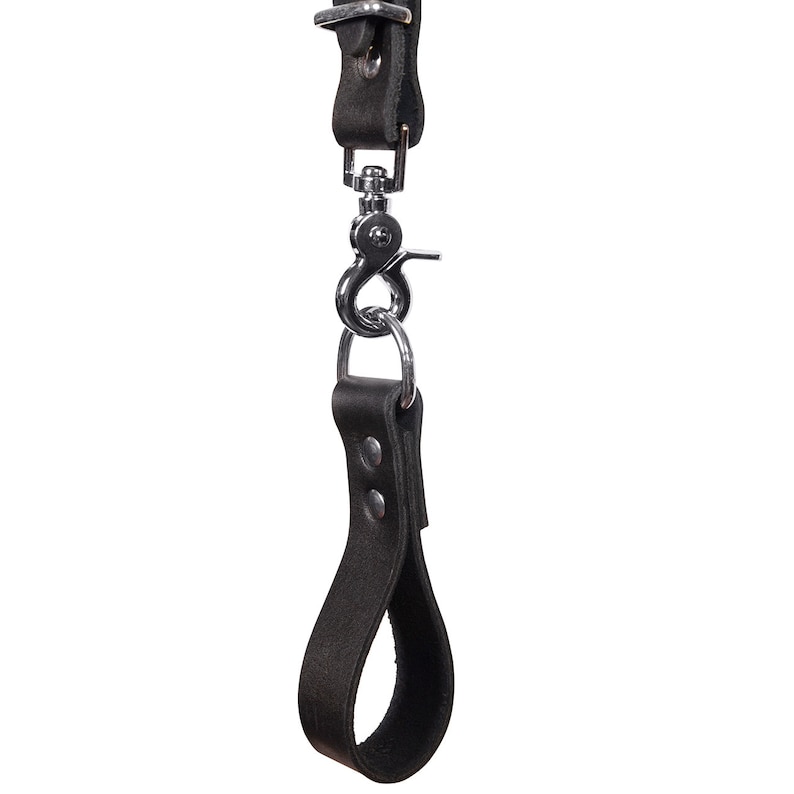 May include: A black leather camera strap with a metal loop and a hand strap.