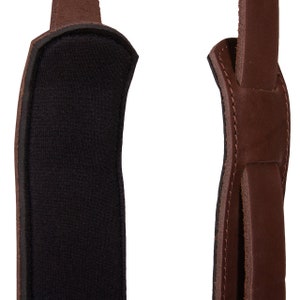 May include: A brown leather camera strap with a black padded section for comfort.