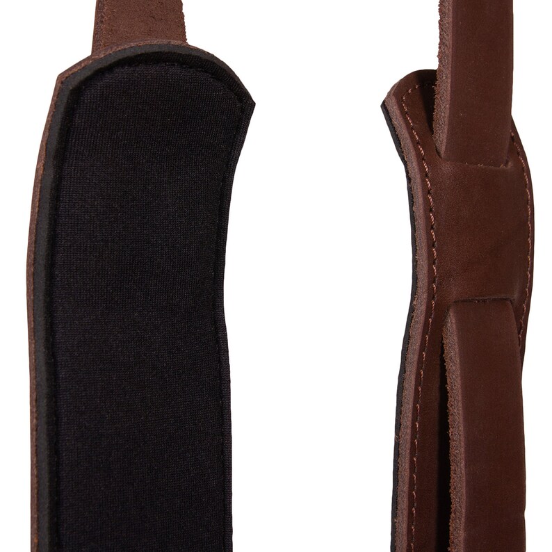 May include: A brown leather camera strap with a black padded section for comfort.