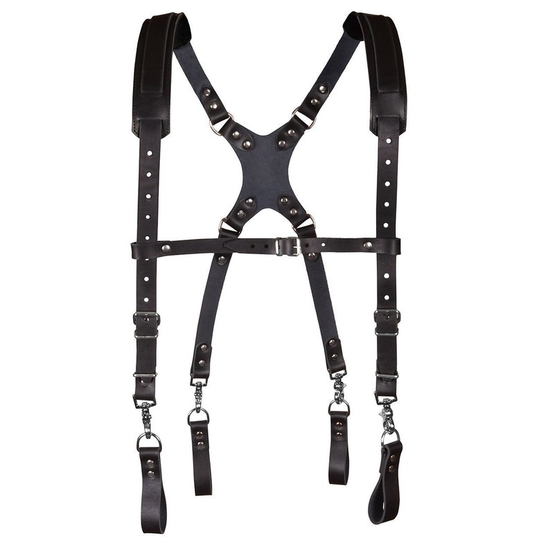 May include: Black leather camera strap with adjustable straps and metal buckles. The strap has a cross-back design and is designed to be worn over the shoulders.