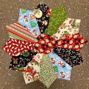 May include: A colorful, star-shaped Christmas trivet. The trivet is made of various fabric patterns, including snowmen, candy canes, and Christmas trees. The trivet is a festive and decorative item for the holiday season.