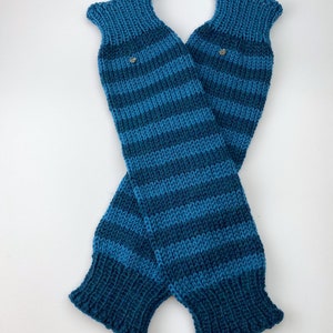 Puede incluir: Un par de polainas de punto a rayas azules y verde azulado. Las polainas est&aacute;n dobladas por la mitad y tienen un peque&ntilde;o bot&oacute;n plateado en cada una.