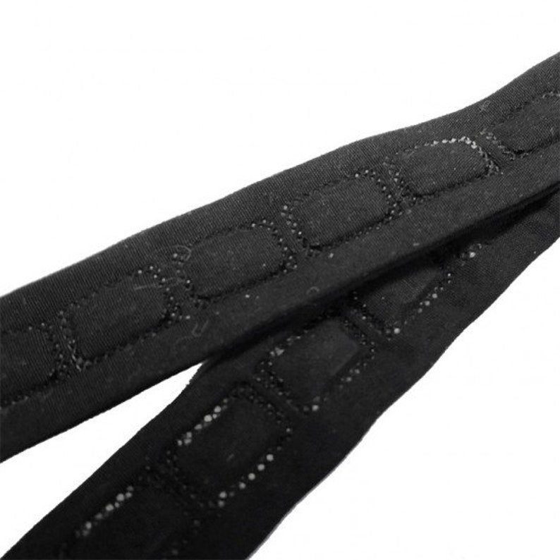 Puede incluir: Primer plano de correas el&aacute;sticas negras con un patr&oacute;n texturizado. Las correas est&aacute;n hechas de un material suave y el&aacute;stico y tienen un brillo sutil.