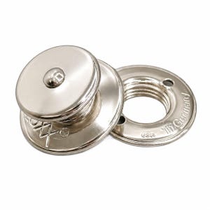 May include: Close-up of two silver-colored metal snap fasteners. One fastener has a domed top with a small button, and the other is a ring with screw threads. The ring is stamped with "The Germany USA".