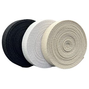 May include: Three rolls of woven ribbon in black, white, and beige. The rolls are tightly wound, displaying a textured surface. The ribbon is likely used for crafting, sewing, or decorative purposes.