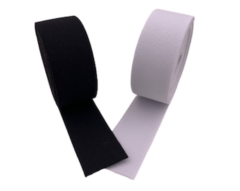 May include: Two rolls of elastic, one black and one white. The elastic is rolled up and the ends are visible.