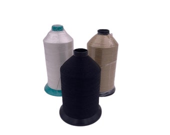 May include: Three spools of thread, one white, one beige, and one black. The spools are all the same size and shape, and they are all wrapped in clear plastic.