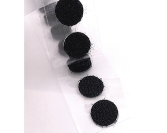 May include: A strip of black hook and loop fastener dots on a clear backing. The circular fasteners are arranged in a vertical line, with a textured surface. The image is on a white background.