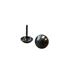 May include: Two antique-style upholstery tacks. One tack has a round, dark metal head and a long, thin stem. The other tack has a rounded head with a short stem and a wide, shallow base. Both tacks have a dark, aged finish.