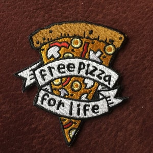 May include: An embroidered iron-on patch featuring a slice of pizza with toppings and a white banner that reads "free pizza for life".