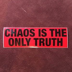 May include: Red sticker with black text that reads "CHAOS IS THE ONLY TRUTH".