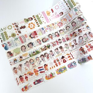 May include: A collection of decorative washi tapes featuring various designs. The tapes showcase illustrations of people, food, and activities, including yoga and dancing. The color palette includes white, pink, green, and brown.