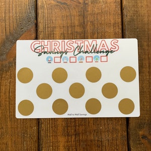 May include: A white printable Christmas savings challenge tracker with gold circles. The text "Christmas Savings Challenge" is written in red and black. The text "Wall to Wall Savings" is written in black at the bottom.