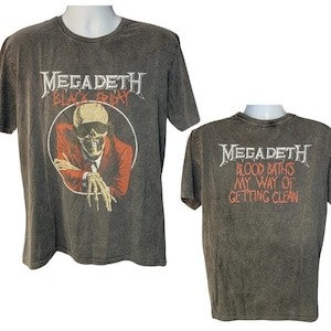 May include: A charcoal gray t-shirt featuring the band name "Megadeth" in a silver font. The front graphic includes a skeleton in a suit with the text "Black Friday". The back of the shirt has the text "Blood Baths My Way of Getting Clean".