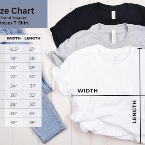 K&ouml;nnte beinhalten: Gr&ouml;&szlig;entabelle f&uuml;r ein Unisex-T-Shirt, mit Ma&szlig;en in Zoll. Die Tabelle enth&auml;lt die Gr&ouml;&szlig;en XS bis 5XL mit den entsprechenden Breiten- und L&auml;ngenma&szlig;en. Drei T-Shirts in Schwarz, Grau und Wei&szlig; sind sichtbar.