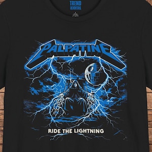 K&ouml;nnte beinhalten: Schwarzes T-Shirt mit einem blauen Aufdruck, der das Wort "Palpatine" in einer stilisierten Schrift, Blitze und eine Darstellung von Darth Sidious zeigt. Der Text "Ride the Lightning" steht darunter.