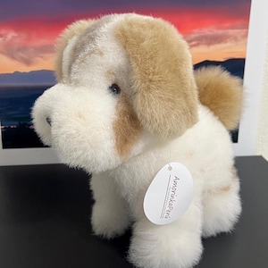 May include: White and brown plush dog toy with a tag that reads "AmorinkaPeri".