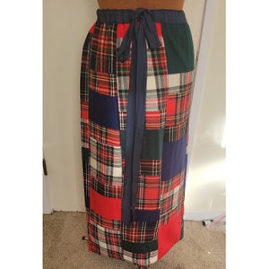 May include: A long red, green, blue, and white plaid wrap skirt with a navy blue tie belt.
